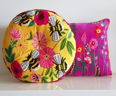 Rond kussen met handgeborduurde bloemen en bijen. Diameter 40cm.