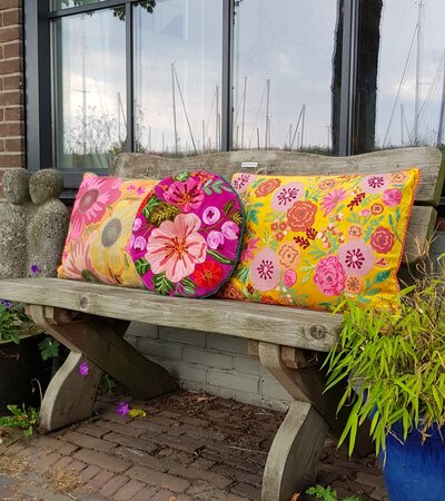 Geel sierkussen met roze bloemen